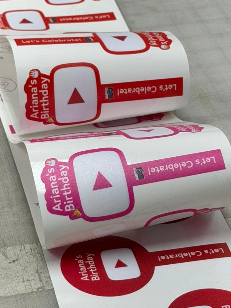 Red and pink Ariana's Birthday stickers on the roll