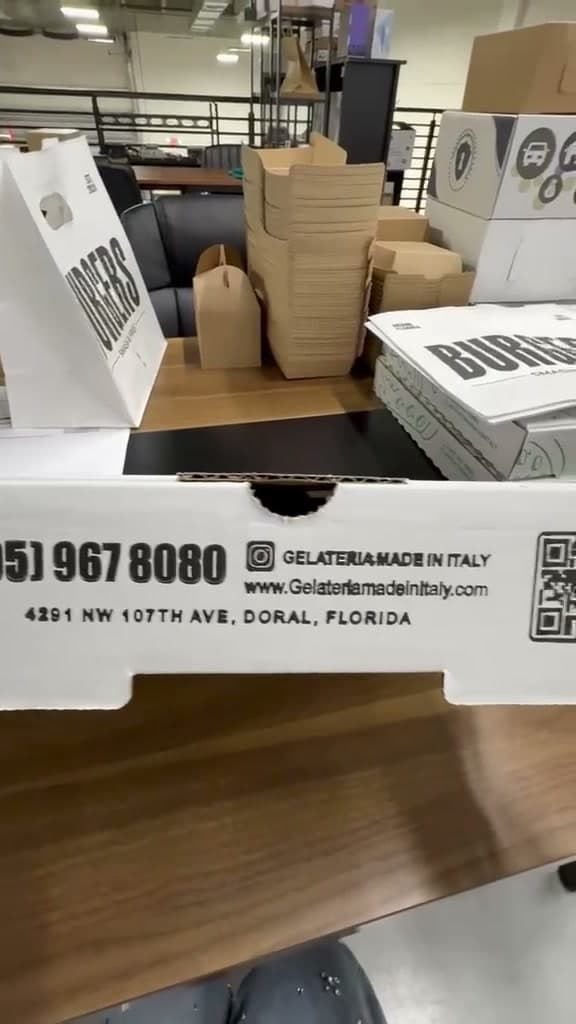 A pizza box printed with Gelateria Made in Italy's contact details
