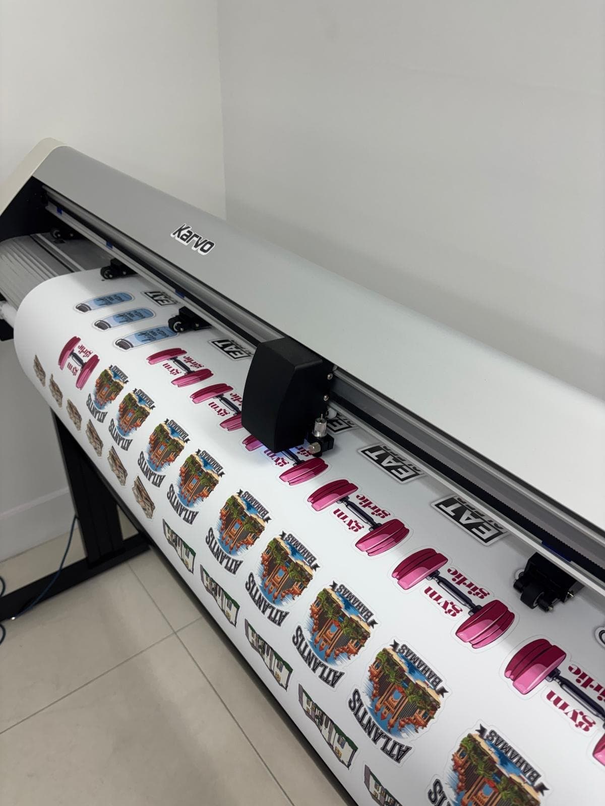 A printed sticker sheet being contour-cut on the studio's cutting plotter