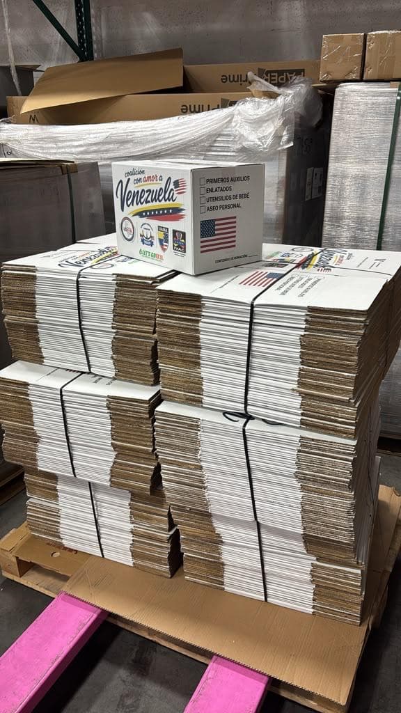 A pallet of flat-packed donation boxes with one made-up box on top
